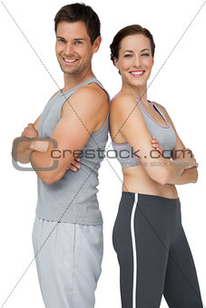 Portrait of a happy fit couple with hands crossed