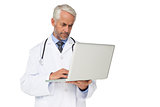 Concentrated male doctor using laptop