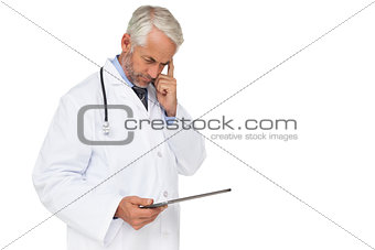 Concentrated male doctor using digital tablet