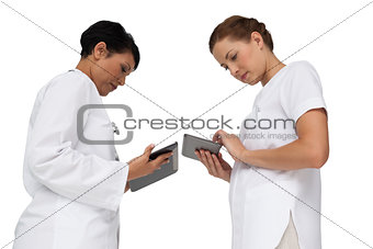 Two female doctors using digital tablets