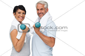 Fit mature couple exercising with dumbbells