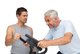 Determined mature man on stationary bike with trainer