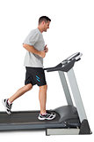 Full length of a young man running on a treadmill