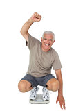 Senior man cheering on weight scale