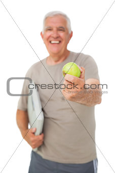 Cheerful senior man with an apple and scales