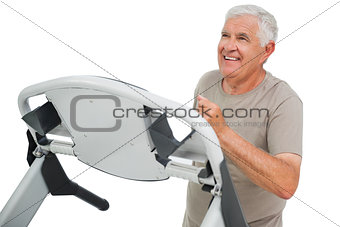 Happy senior man running on a treadmill
