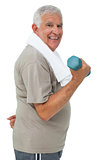 Side view of a senior man exercising with dumbbell