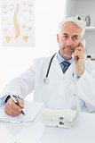 Male doctor writing reports while on call