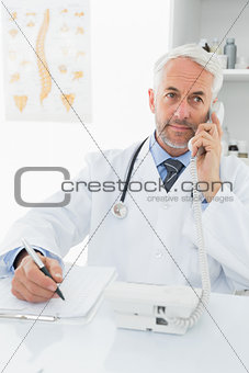 Male doctor writing reports while on call