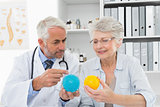 Doctor showing stress buster balls to senior patient