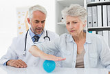 Male doctor with senior patient using stress buster ball
