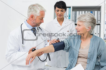 Doctor measuring blood pressure of a senior patient
