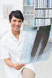 Portrait of a smiling female doctor examining x-ray