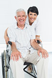 Portrait of a nurse with senior patient sitting in wheelchair