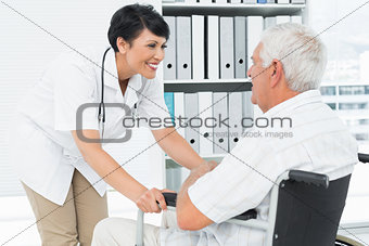 Female doctor talking to a senior patient in wheelchair