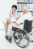 Female doctor talking to senior patient in wheelchair