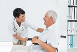 Female doctor talking to senior patient in wheelchair