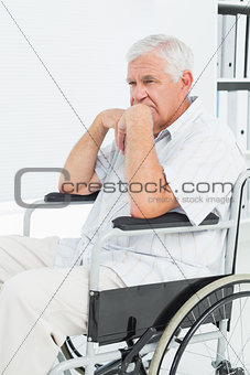 Side view of a sad senior man sitting in wheelchair