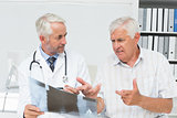 Male doctor explaining x-ray report to senior patient