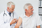 Doctor injecting senior male patient
