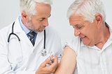 Doctor injecting senior male patient
