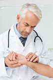 Male doctor taking a patients pulse
