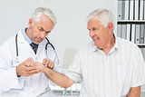 Male doctor taking a senior patients pulse