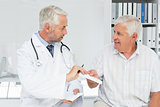 Male doctor giving a prescription to his senior patient