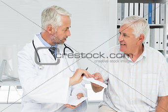 Male doctor giving a prescription to his senior patient
