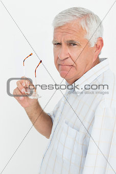 Portrait of a senior man holding glasses