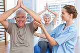 Therapist assisting senior couple with exercises