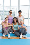 Happy sporty women sitting in yoga class