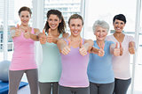 Women gesturing thumbs up in the yoga class