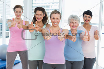 Women gesturing thumbs up in the yoga class