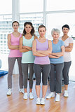Confident women with arms crossed in yoga class