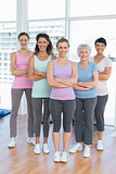 Happy women with arms crossed in yoga class