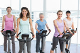 Happy women working out at spinning class