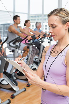 Trainer with people working out at spinning class