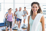 Cheerful woman with people exercising at fitness studio