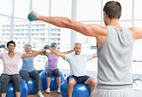 Fitness class with dumbbells sitting on exercise balls