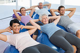 Smiling people stretching on exercise balls