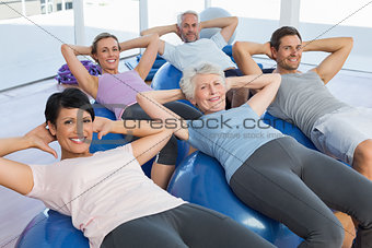 Smiling people stretching on exercise balls