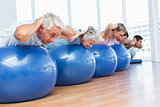 People stretching on exercise balls in gym
