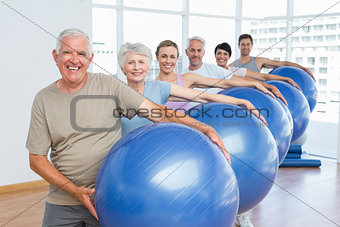 Sporty people carrying exercise balls in bright gym