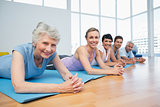 Fitness group lying in row at yoga class