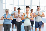 Sporty people with joined hands at fitness studio