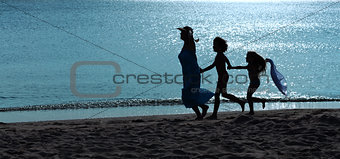 Morning exercise - woman and kids running on the beach