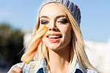 Beautiful blonde girl in beanie hat with smokey eye make up who 
