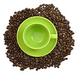 Green cup and saucer in the coffee beans