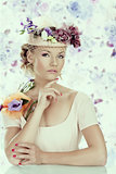 girl with flowers on the hat and hand under the chin